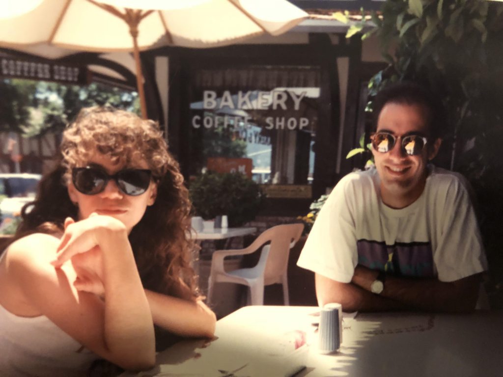 Roxanne Ornelas (on left) and Kris Haltmeyer (on right) seated at an outdoor cafe table in 1991