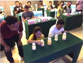 Trainees kneel while examining different species of tapeworms at table