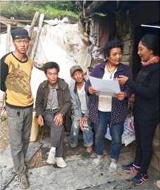 Dr. Tsering Yangzom, medical doctor, Dongla Village, Shuiluo Township, educating local residents about NCC with the two laminated photo sheets that she received at the training in Xichang